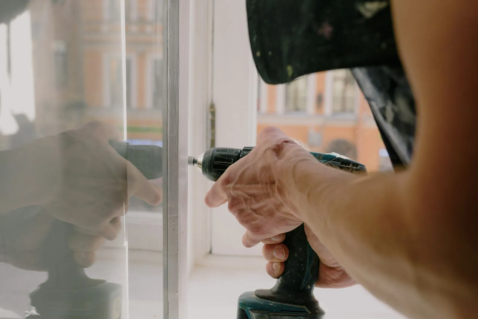 Artisan posant une fenêtre à la visseuse pendant des travaux de rénovation