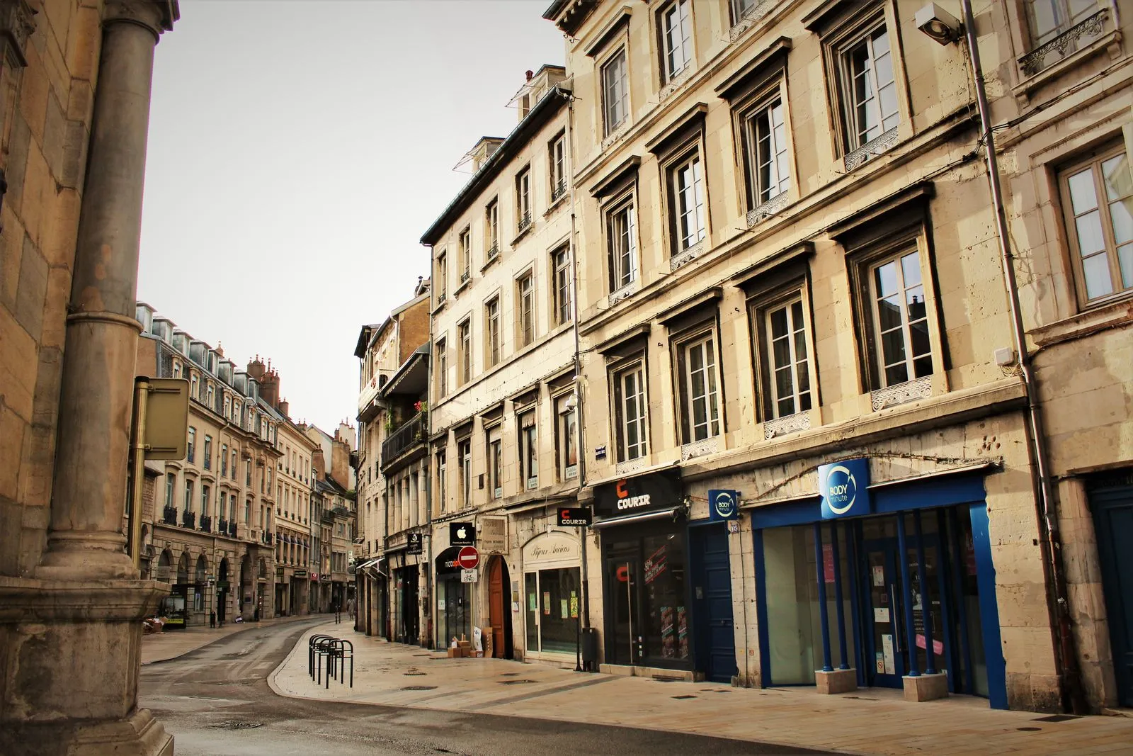 Rue commerçante bordée d'immeubles anciens dans le centre d'une ville moyenne